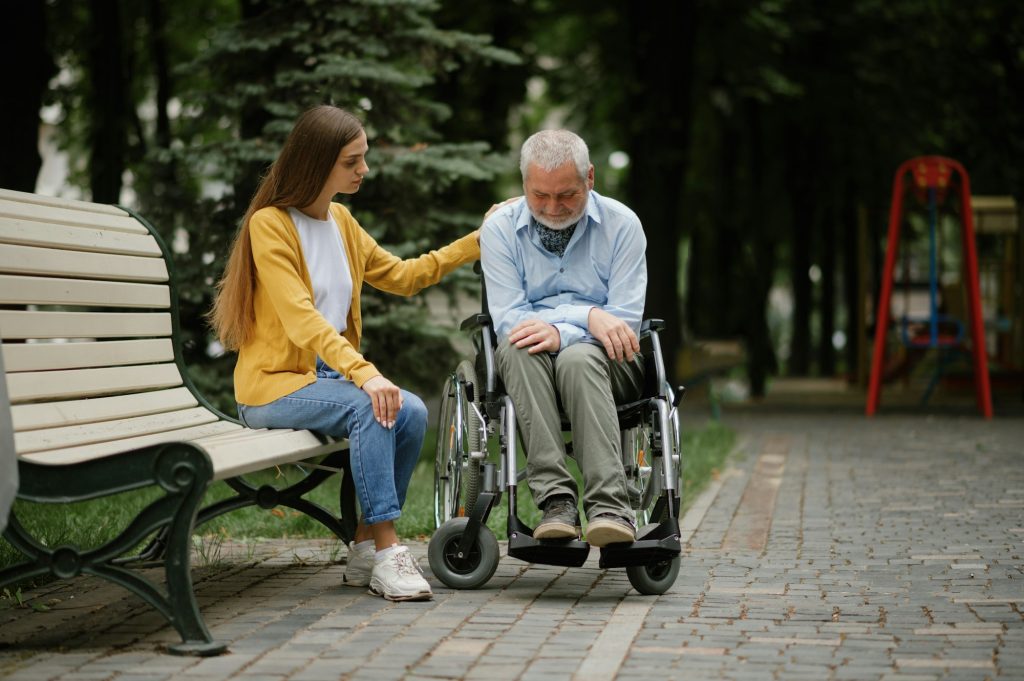 Woman takes care of disabled father in wheelchair