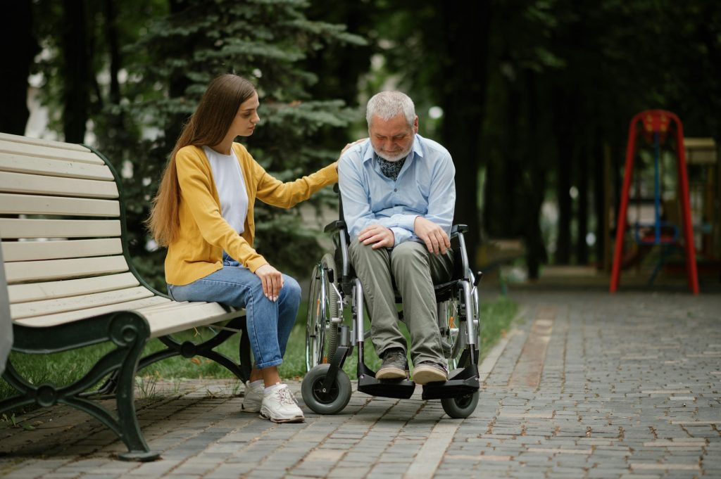 Woman takes care of disabled father in wheelchair